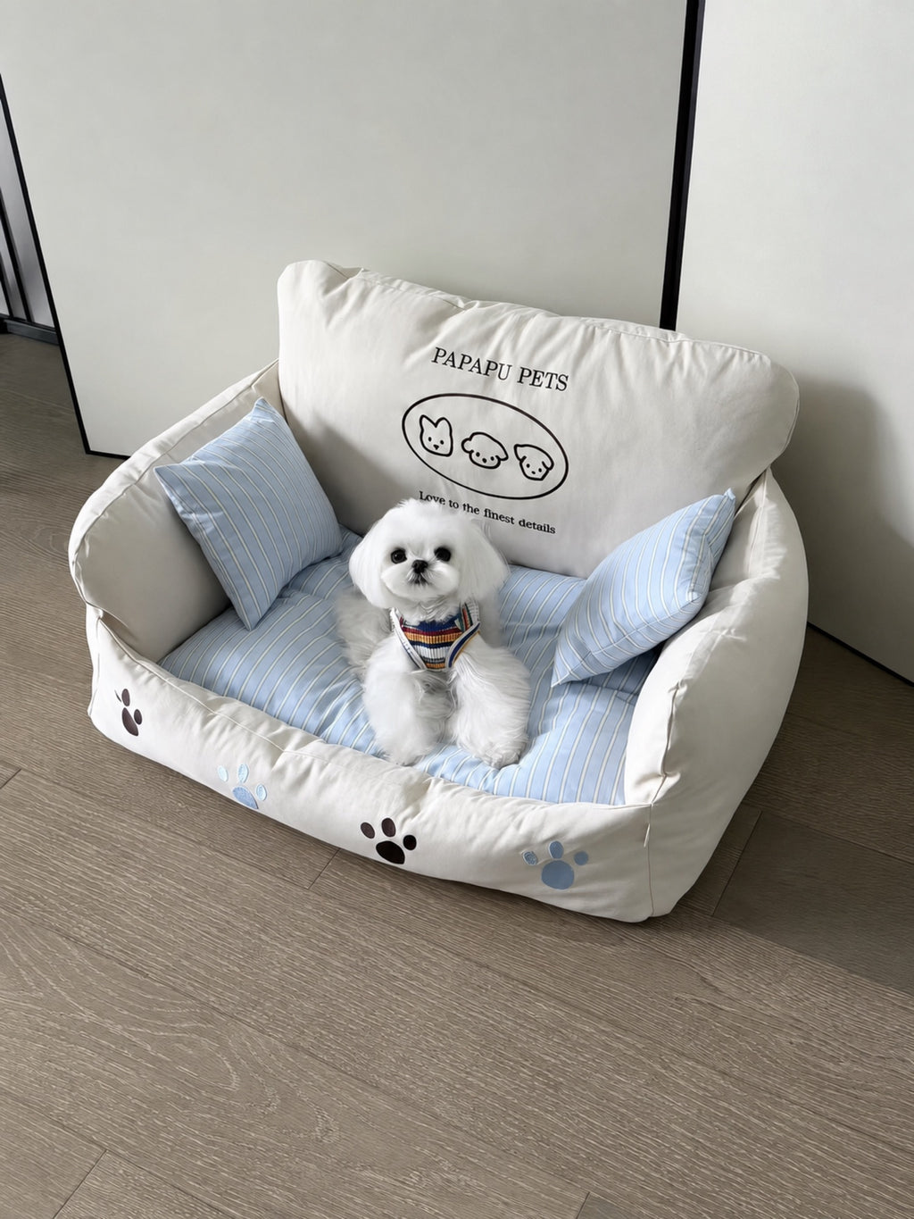 Small white dog resting on PrismTail Cove Sofa cream couch-style pet bed